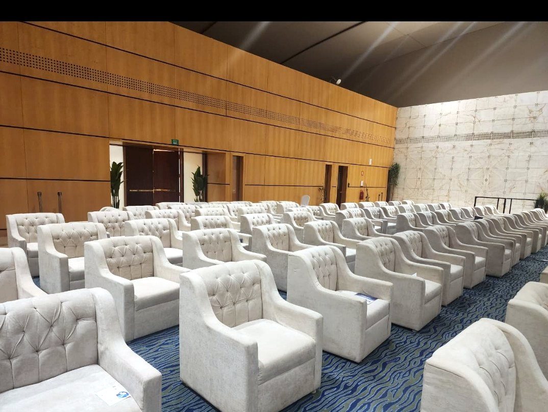 Hall arranged with rows of cream tufted single-seat sofas for a conference in Riyadh