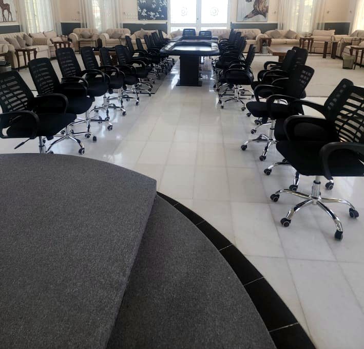 Exhibition stand furnished with round white tables and modern chairs