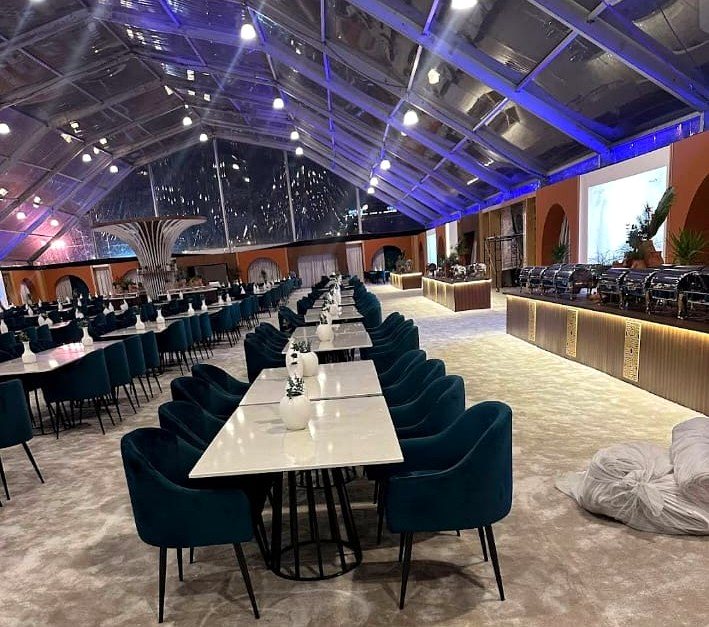 Long boardroom table with executive chairs inside an event tent