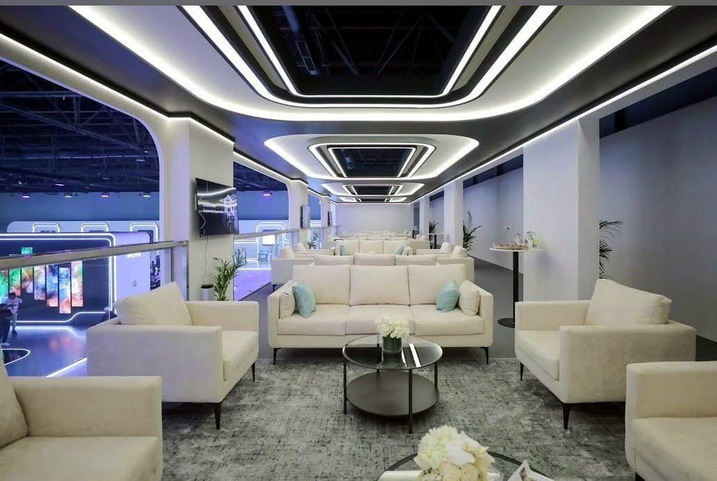 Modern exhibition lounge furnished with cream sofa sets and coffee tables